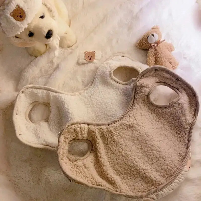Lit de bébé avec ours en peluche et animal en peluche présentant le manteau Comfort Coat de Polaire pour chiens et chats