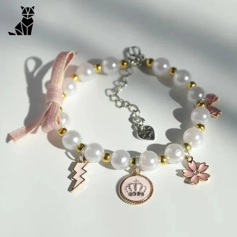 Bracelet avec ruban rose et breloques sur surface blanche pour les occasions spéciales